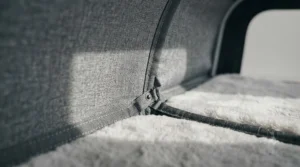 A close-up of the premium travel system branding tag stitched onto the side of a grey cat travel carrier.