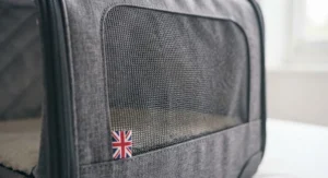 Breathable mesh window panel on the side of the rolling cat carrier.
