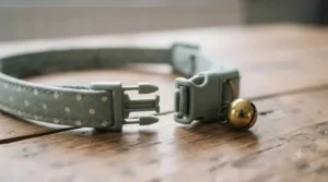Close-up of a breakaway safety buckle on a bell collar for cats designed to snap open under pressure.