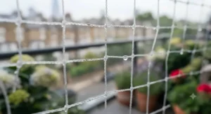 Tabby cat safely relaxing and enjoying the fresh air behind a protective balcony net.
